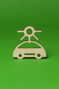 Wooden model of an electric car with a charging plug on its roof